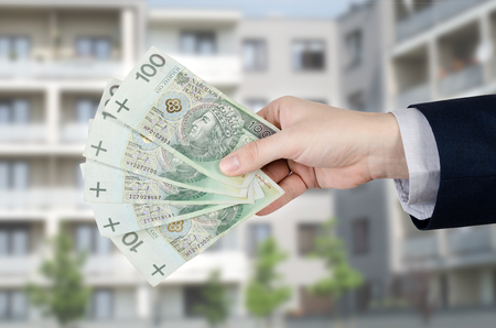 Home loan or investment in an apartment. Real estate agent holds Polish moneyの写真素材