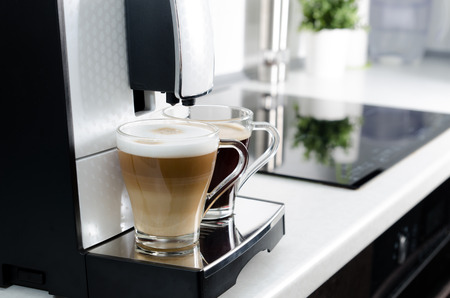 Two cups of coffee, home professional coffee machine. coffee machine latte macchiato cappuccino espresso milk foam conceptの写真素材