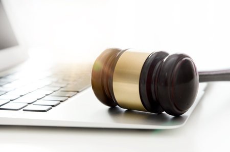 Wooden gavel on laptop keyboard. auction, online, law, technology, justice conceptの写真素材