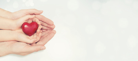 Parent and child holding heart in hand. Health care, family insurance conceptの写真素材