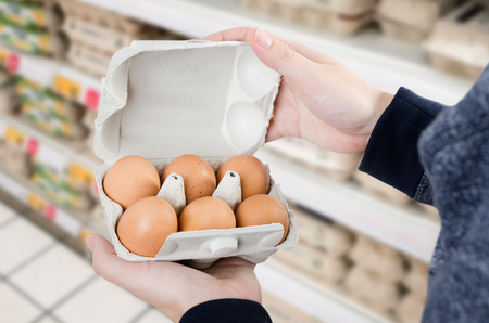 Man buys eggs in the supermarket. Egg store supermarket price expensive grocery shop conceptの写真素材