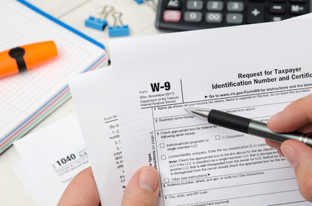 Man holding US tax form W-9. Tax form law document irs business conceptの写真素材