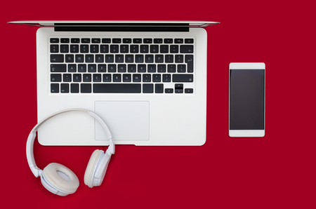 Office desk table with laptop, smartphone, and headphones. Flat lay conceptの写真素材