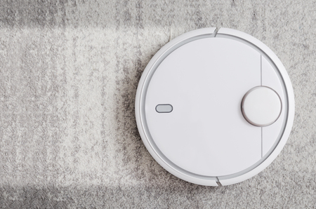 Robotic vacuum cleaner working on carpet top view conceptの写真素材