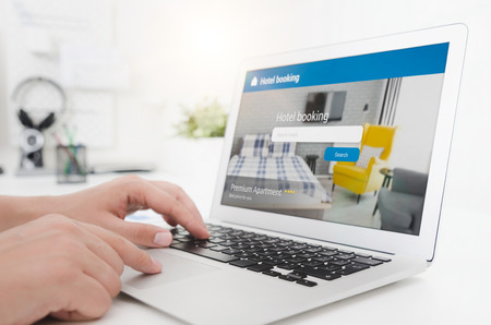 Person booking hotel room on laptop. Premium apartment reservation concept.の写真素材