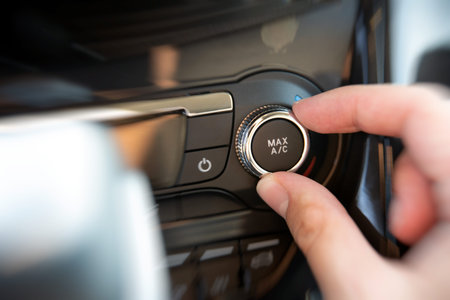 Man turning on car air conditioning system. Air conditioning button inside a car.