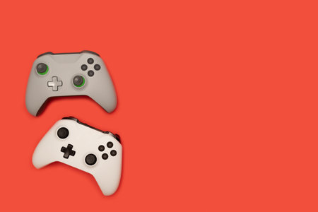 Two game pads isolated on red background. Video gaming concept.