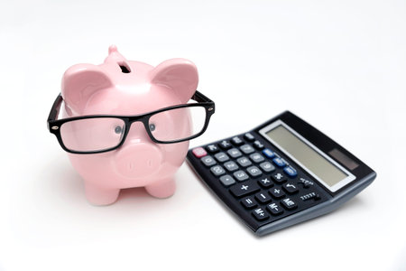 Piggy bank and calculator on white background. Savings and budget concept