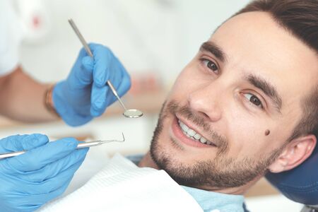 Young man at the dentist. Dental care, treatment of teeth, taking care of teethの写真素材