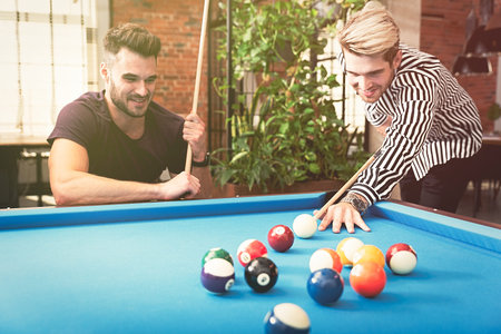 Employees playing in billiards at office. Break from work in the relaxation room