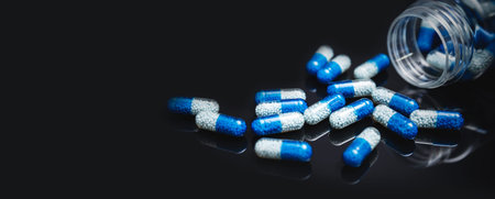 Pile of spilled capsules on a black background. Pharmacy concept