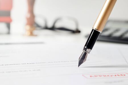 Notary signs legal contract. Close up of fountain pen on paperの写真素材