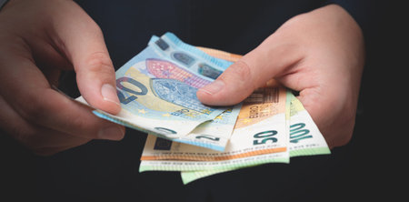Man in a suit counts Euro banknotes. Business and finance, salary concept