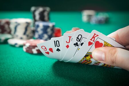 Man plays poker in the casino. Holding cards in hand, gambling conceptの写真素材
