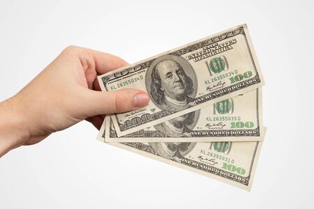 Hand holding USD banknotes. US currency, salary or loan concept, hand isolatedの写真素材