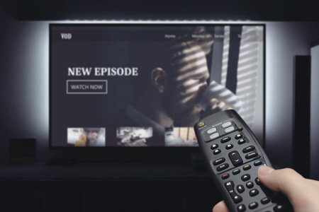 VOD service on television. Man watching TV, streaming service, video on demand, remote control in...