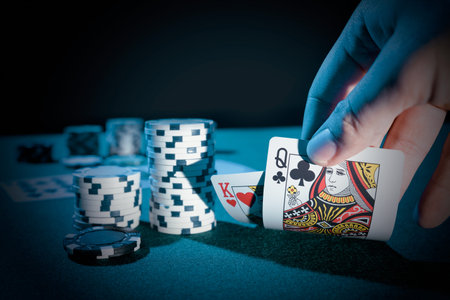 Man plays poker in the casino. Holding cards in hand, gambling concept