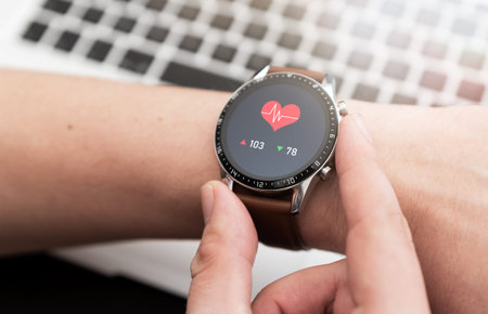 Hands with heart icon on smartwatch. Heart rate measurementの写真素材