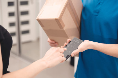 Courier delivery service. Customer receives the parcel on phoneの写真素材