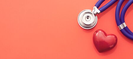 Red heart with stethoscope on red background. Wide image for web banner backgroundの写真素材