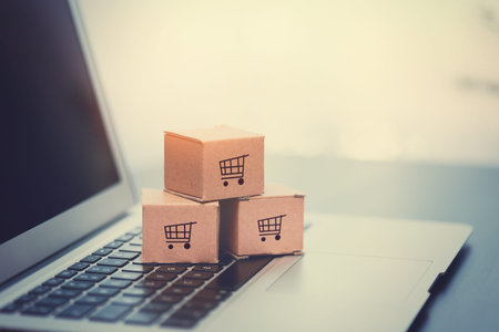 Boxes on laptop keyboard. E-commerce, online shopping concept.