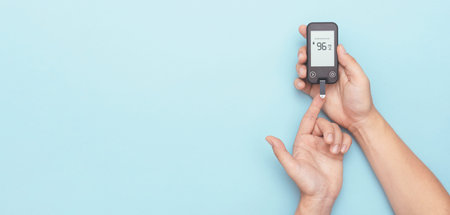 Man using glucometer, checking blood sugar level. Wide image with copy space, blue background....