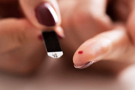 Woman checking blood sugar level. Diabetes health care conceptの写真素材
