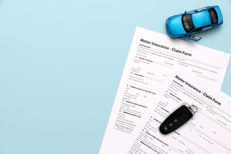 Car insurance, insurance contract and car keys on a blue backgroundの写真素材