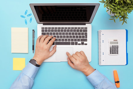 Workspace with laptop, office supplies. Man working on stylish table desk