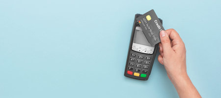 Credit card payment terminal. Man using credit card. Wide image with copy space and blue background