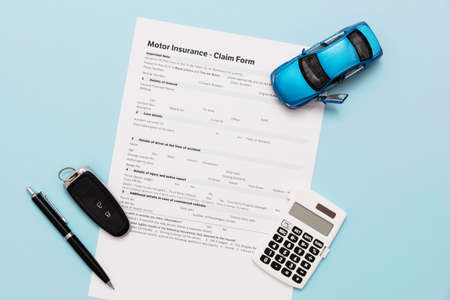 Car insurance, insurance contract and car keys on a blue backgroundの写真素材