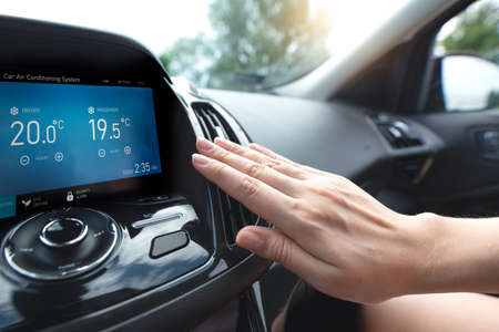 Car air conditioning. Woman checks air conditioning in a carの写真素材