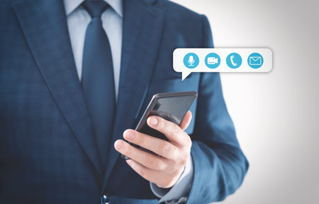 Businessman holding smartphone with contact icons. Social media, video chat consultation concept