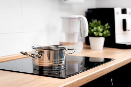 Pot in the kitchen on the induction hob. Induction electrical stoveの写真素材
