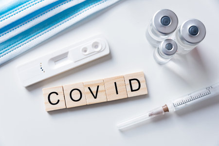 Vaccination concept, coronavirus vaccination, medical equipment, COVID word from wooden tiles
