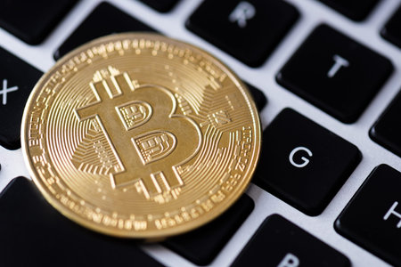 Golden coins with bitcoin symbol on laptop keyboard