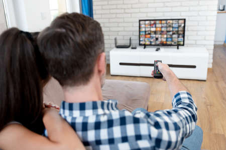Couple watching TV on sofa. Television, multimedia, leisure conceptの写真素材