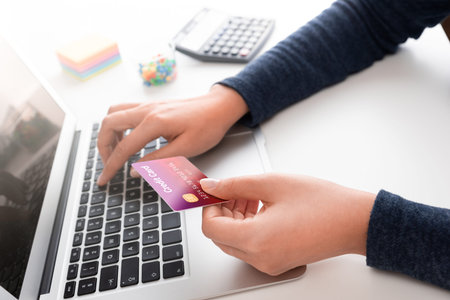 Woman using laptop, online shopping concept, credit card in hands