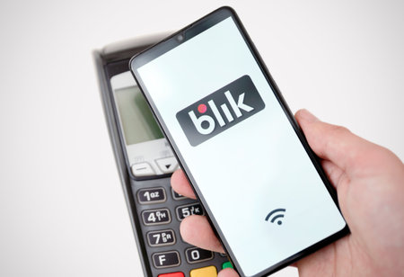 Wroclaw, Poland - NOV 06, 2019: Man holding smartphone with Blik logo, contactless payment. Blik is Polish most popular quick payment method in Poland.のeditorial素材