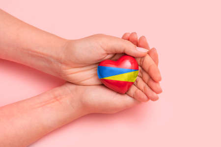 Hand holding a heart with Ukrainian national colors. Help Ukraine during the warの写真素材