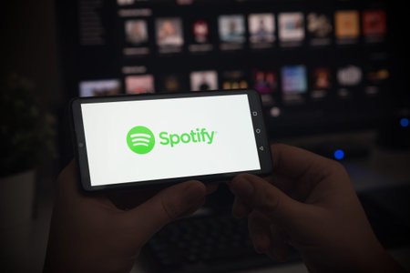 Wroclaw, Poland - JAN 27, 2022: Man with Spotify logo on screen. Spotify is most popular music...