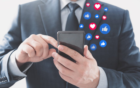 Businessman using social media. Icons flying from the smartphone.