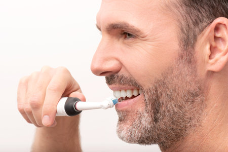 Man using electric toothbrush. Dental care concept