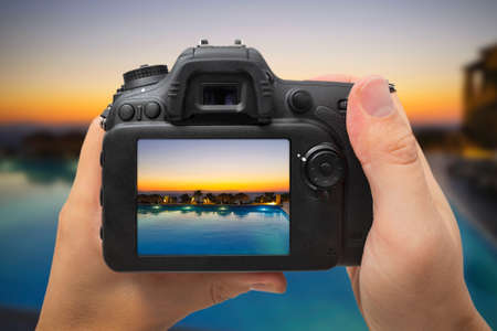 Back of DSLR digital camera. Camera with swimming pool and sunset, travel photoの写真素材