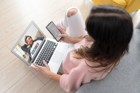 Woman is having a video call on laptop. Young woman using video chat at home