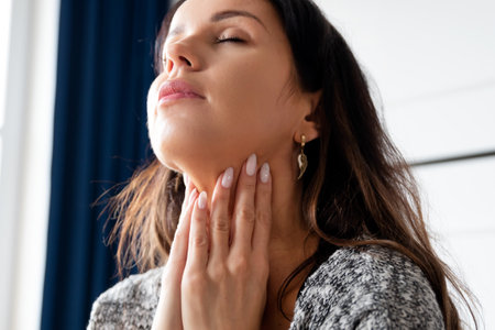 Young woman self examination thyroid gland. Hashimoto or thyroid cancer conceptの写真素材