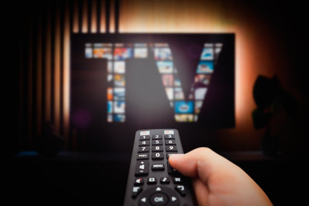 VOD service screen. Man watching TV with remote control in hand.の写真素材