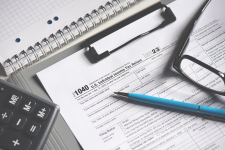 Tax income concept with calculator, a pen and a tax form are on a table