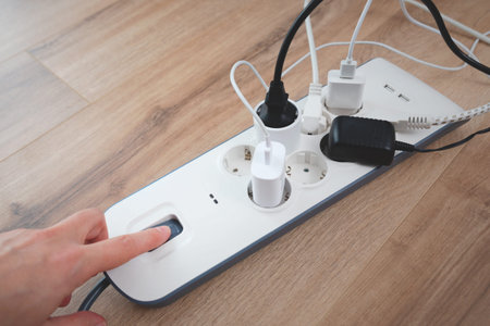 Man plugging the power plug. Electrical plug in outlet socket at home.