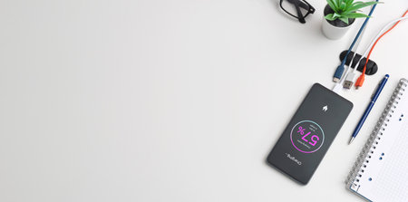 Charging phone on desk, multiple USB cables, copy spaceの写真素材